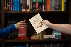 A copy of Between the Lines and Blueprints being handed over in a bookstore